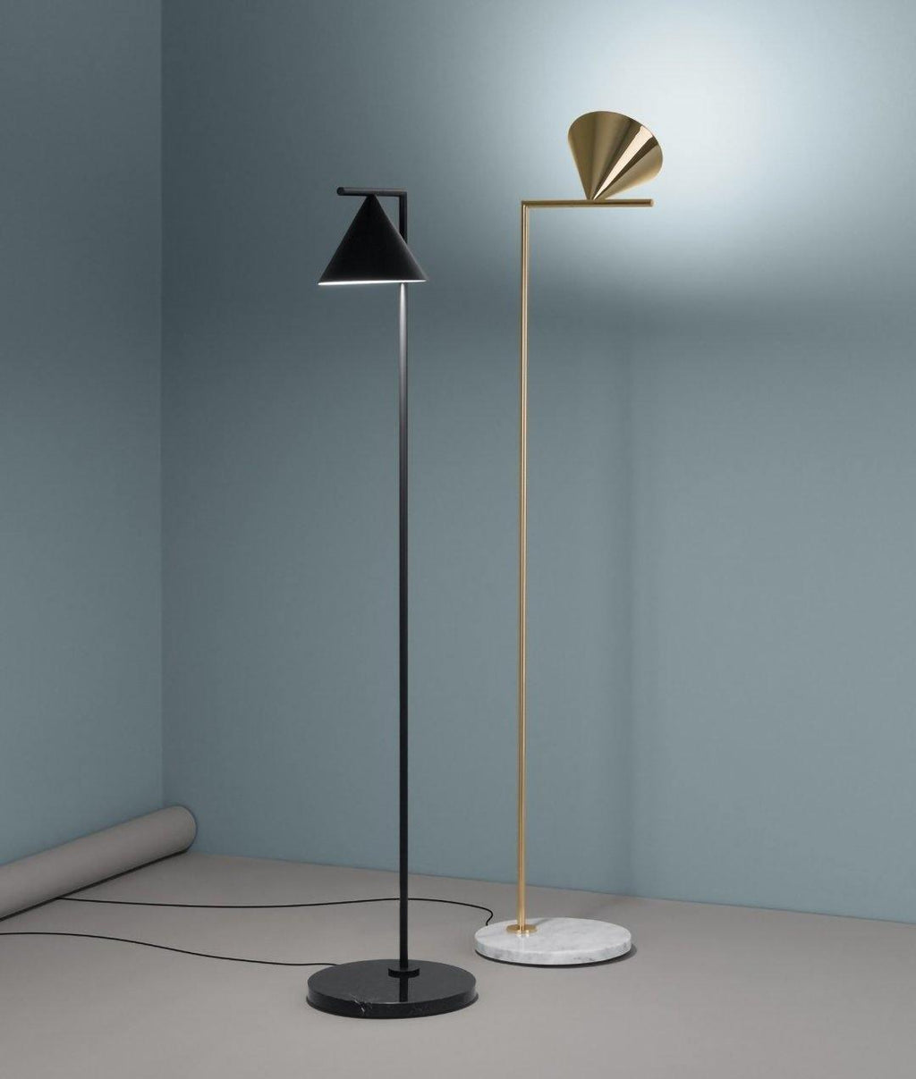 Black-stem floor lamp with cone angled over a side table