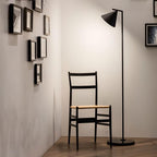 Copper-stem floor lamp with opal cone in a cozy room