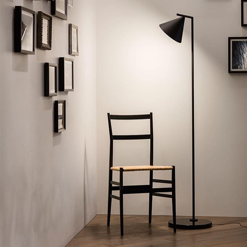 Copper-stem floor lamp with opal cone in a cozy room