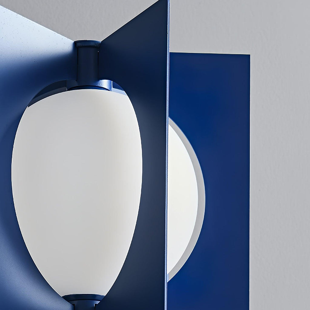 Extreme close-up of the Clérachic lamp's glowing oval shade nested between overlapping navy metal fins.
