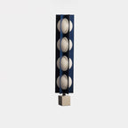 Four-globe Clérachic floor lamp in dark navy on a pale stone base, an isolated product shot on plain white.