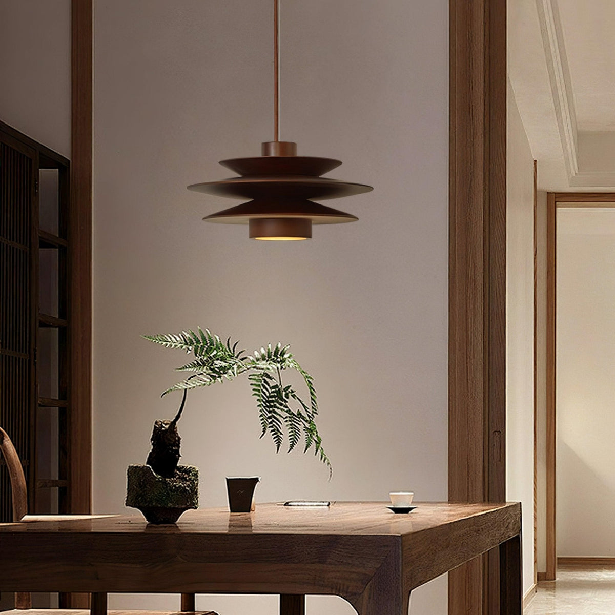 In a warm hallway, this Clérachic pendant in walnut wood hangs above a dark wood table with a small potted fern.