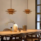Three of this Clérachic pendant in nature wood line a long dining table set with vases and candle holders near tall windows.