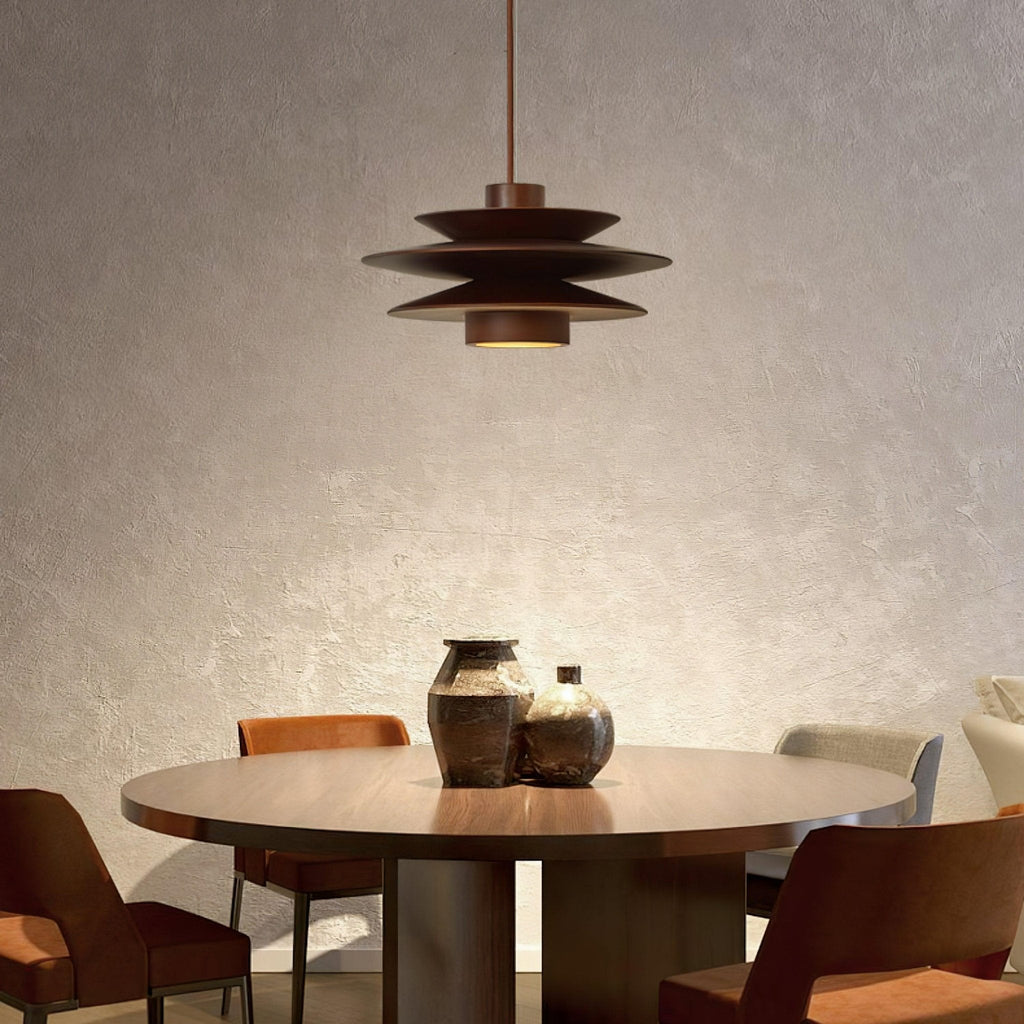 Hung low over a round dining table, this Clérachic pendant in walnut wood sits between two seating areas in a plaster-walled room.