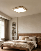 Warm light from this Clérachic ceiling fixture spills over a bed set in a window nook lined with built-in shelving.