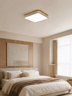 This Clérachic flush mount light glows softly above a bed set against a textured plaster wall panel.