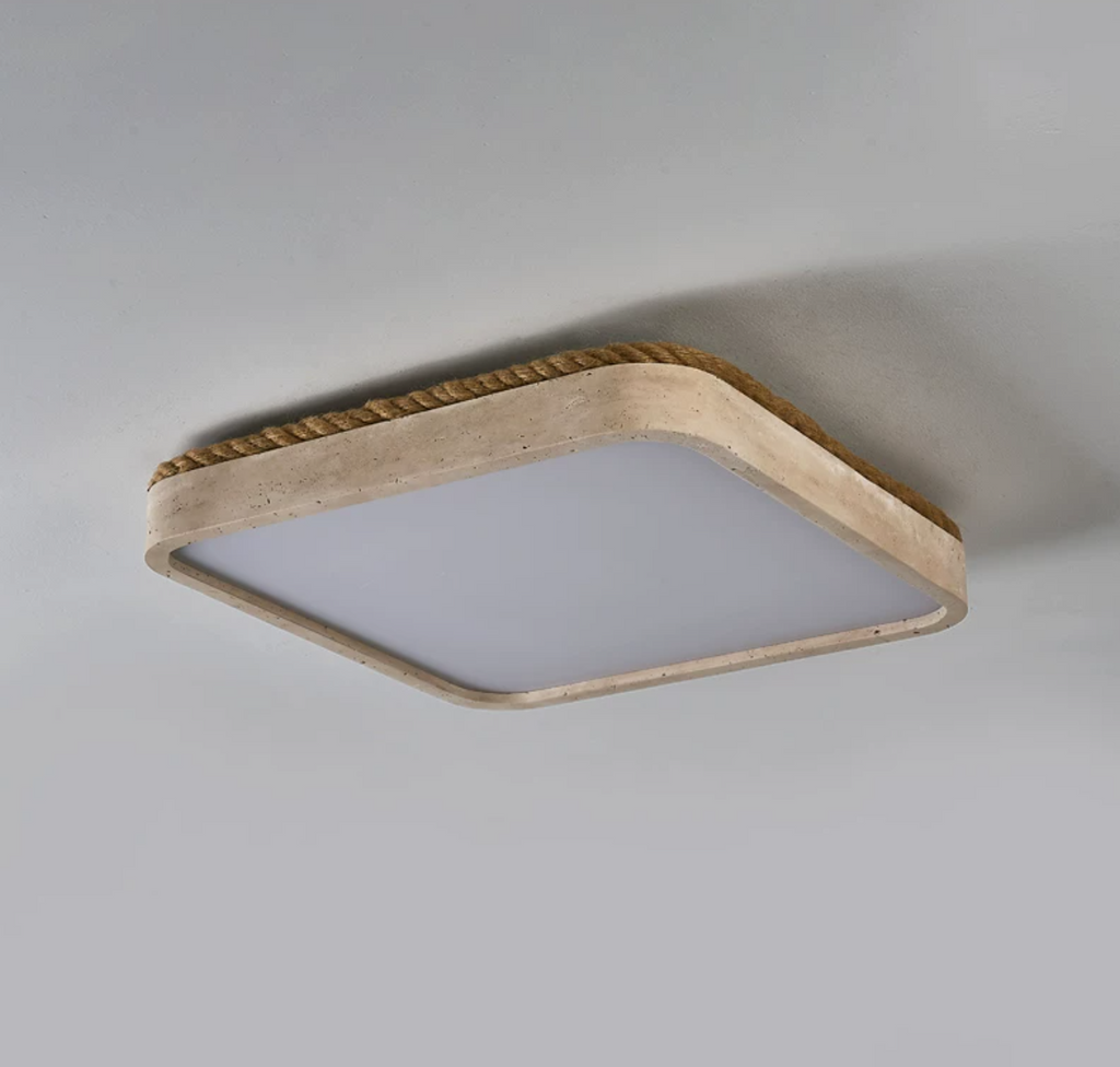 Close angled view of the wound jute rope trim on this Clérachic flush mount ceiling light, its travertine edge catching the light.
