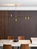With gold heads bright against dark panelling, this Clérachic chandelier hangs above a marble table edge and black bowl.