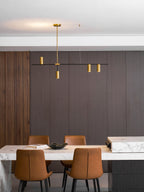 In a brown panelled dining room, this Clérachic chandelier's gold heads glow warm above a marble-topped table.