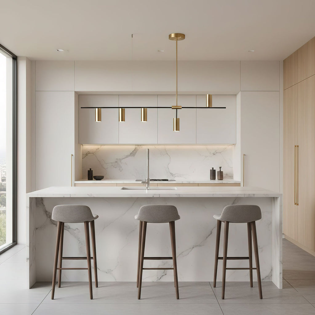This Clérachic chandelier's black bar and brushed gold cylinder heads hang above a marble kitchen island with three tan stools.