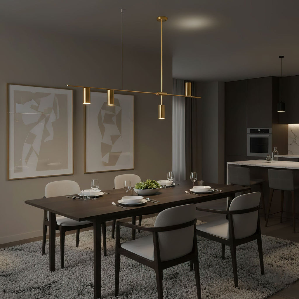 Above a set dining table, this Clérachic chandelier's gold heads glow warm in a dark, moody dining room.