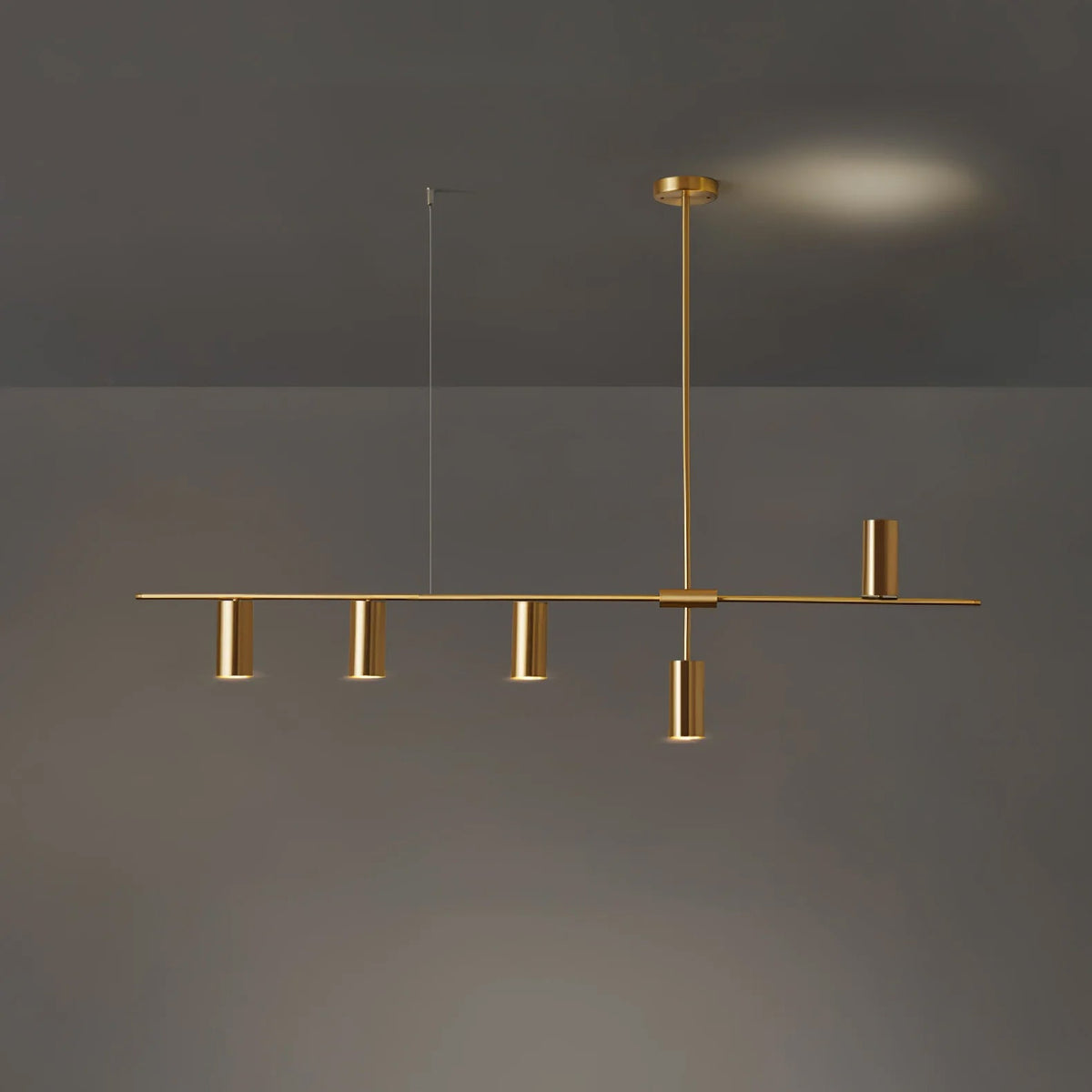 Against a dim grey backdrop with a warm glow behind, several gold cylinder heads cluster along this Clérachic chandelier's black bar.