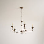 Candle chandelier viewed at an angle showing depth of the brass arms