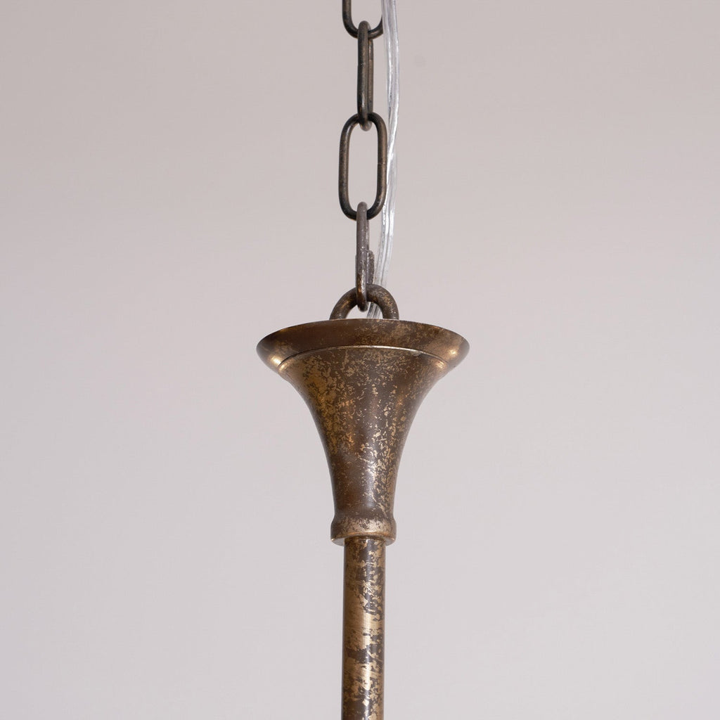Candle chandelier arm detail in warm brass tone