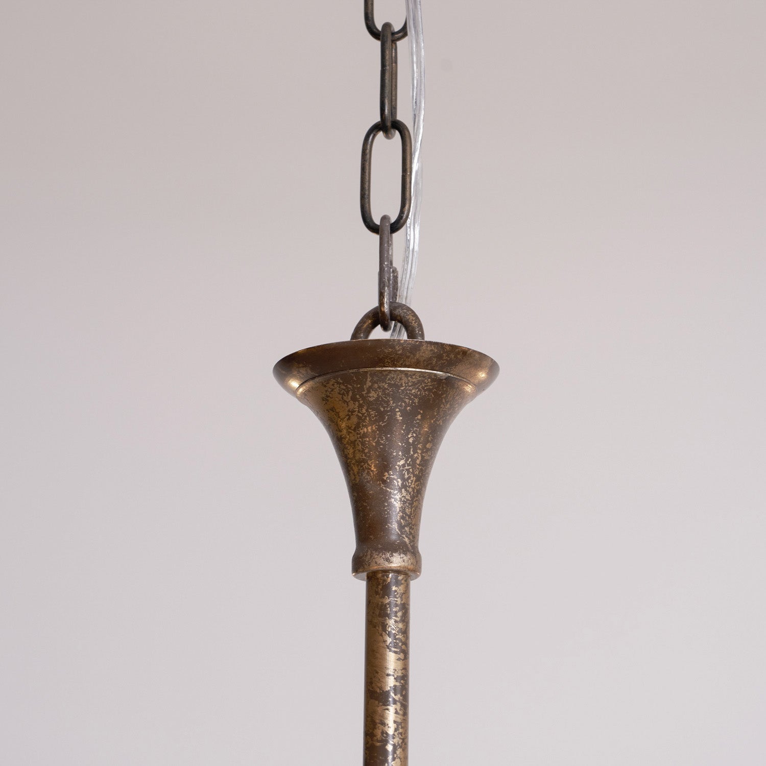 Candle chandelier arm detail in warm brass tone