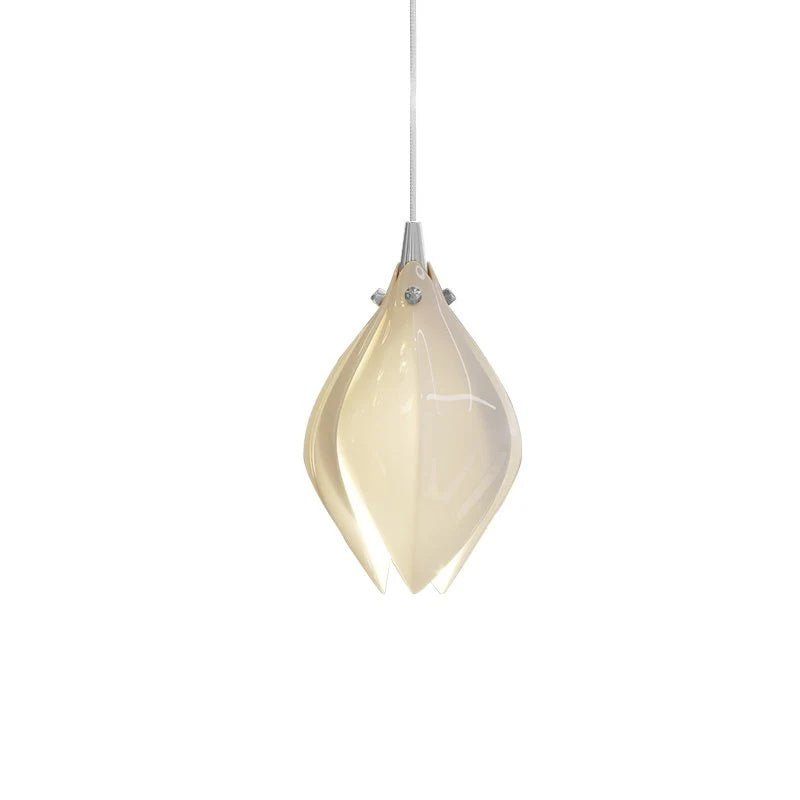 Brass and white ceramic bloom pendant light hanging over a table