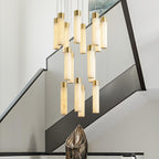 The chandelier hung beside a black-railed staircase, a bronze sculpture on the console below.