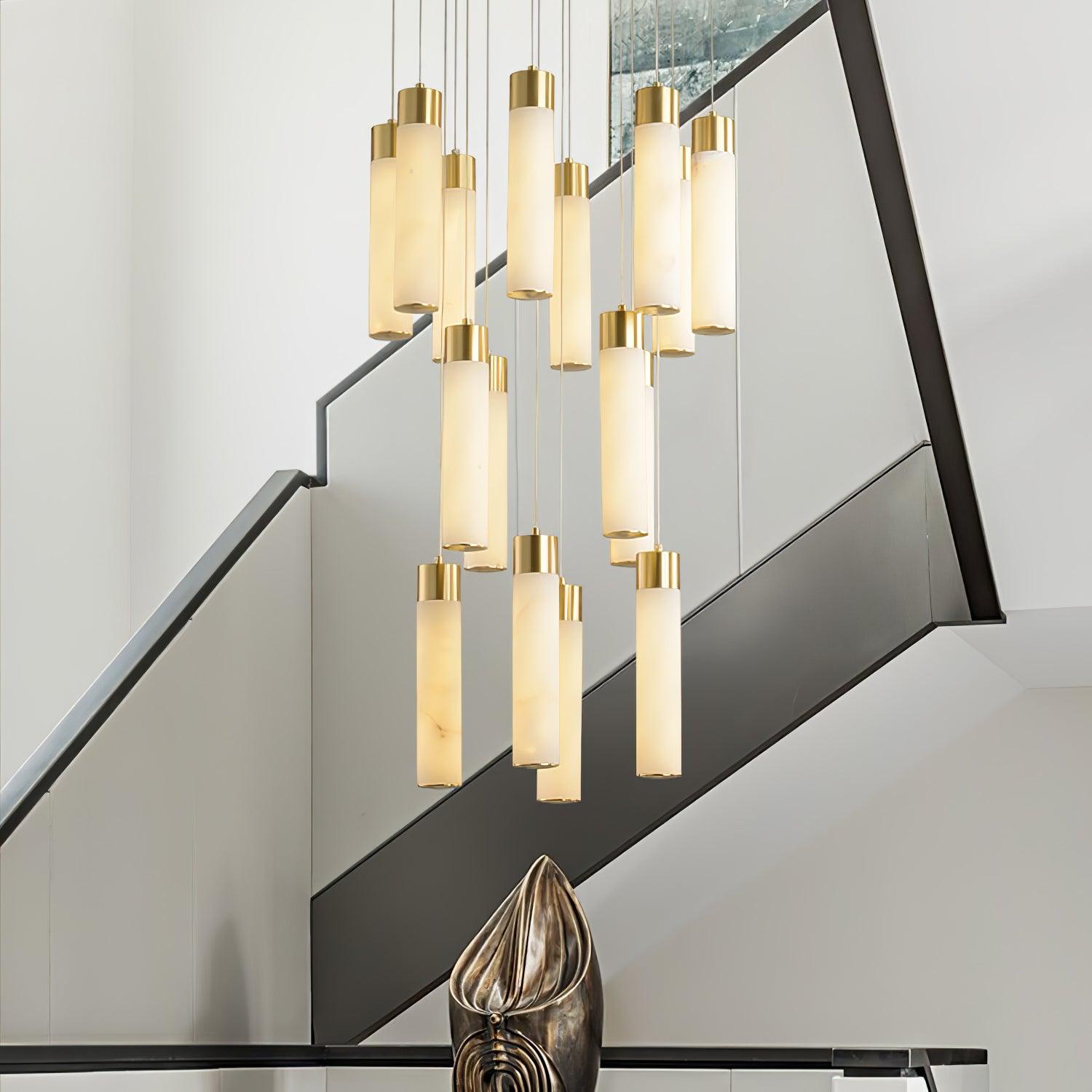 The chandelier hung beside a black-railed staircase, a bronze sculpture on the console below.