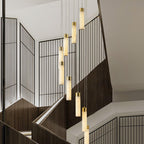 Aurelia pendants dropping through a stairwell framed by black grille screens and dark timber.