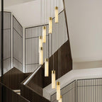 Eight Aurelia pendants stepping down a stairwell, seen at an angle across the black screen wall.