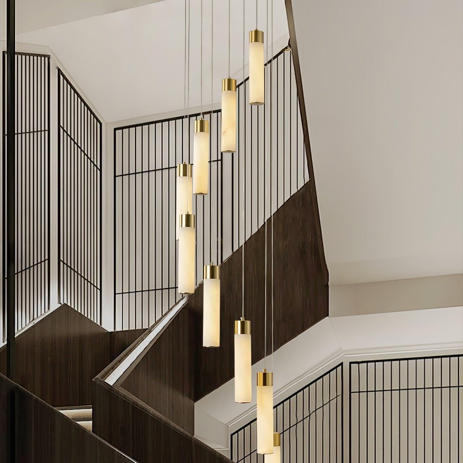 Eight Aurelia pendants stepping down a stairwell, seen at an angle across the black screen wall.