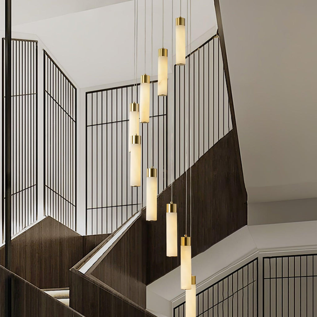 Aurelia pendants lit in the evening over a dark-timber staircase with black grille screens.