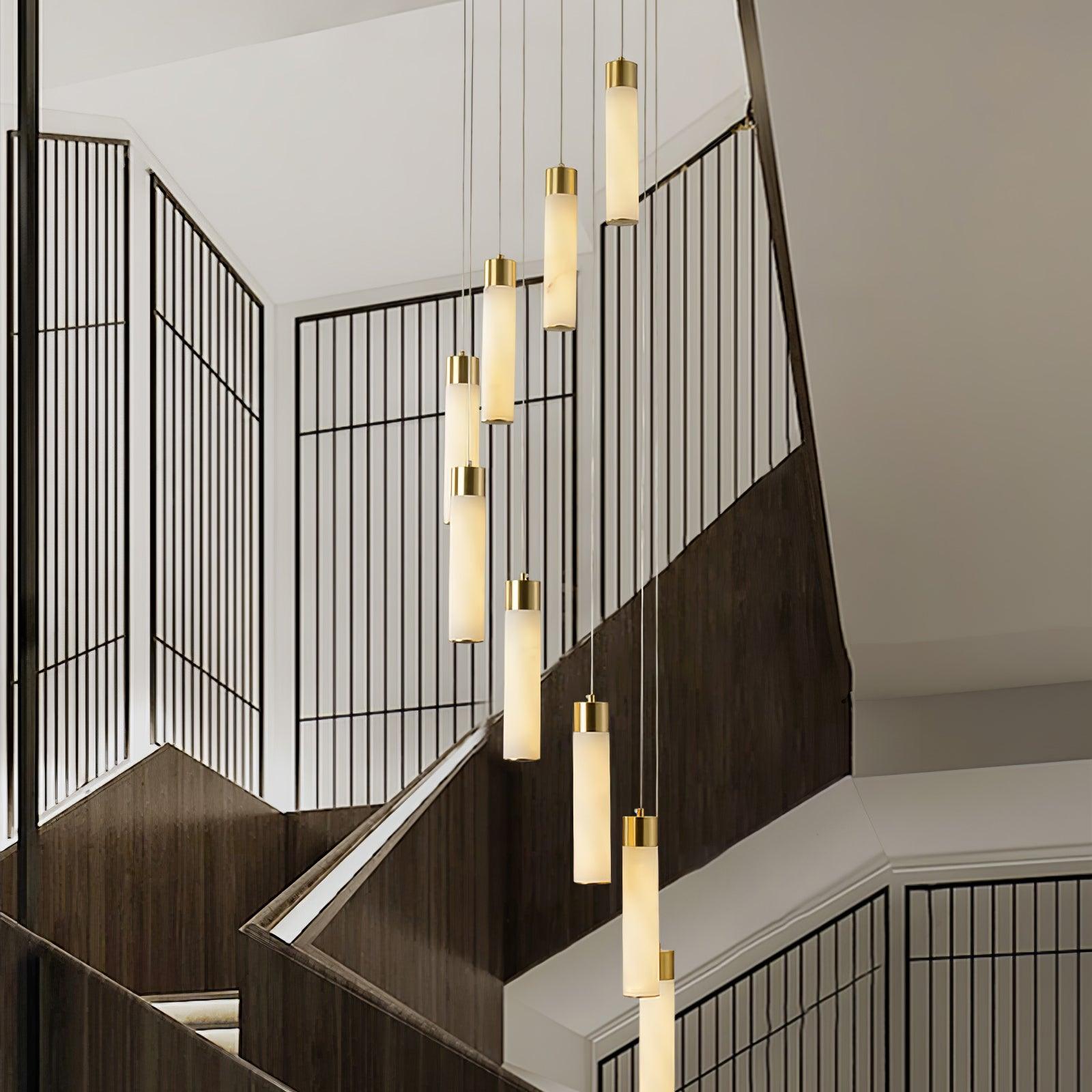 Aurelia pendants lit in the evening over a dark-timber staircase with black grille screens.