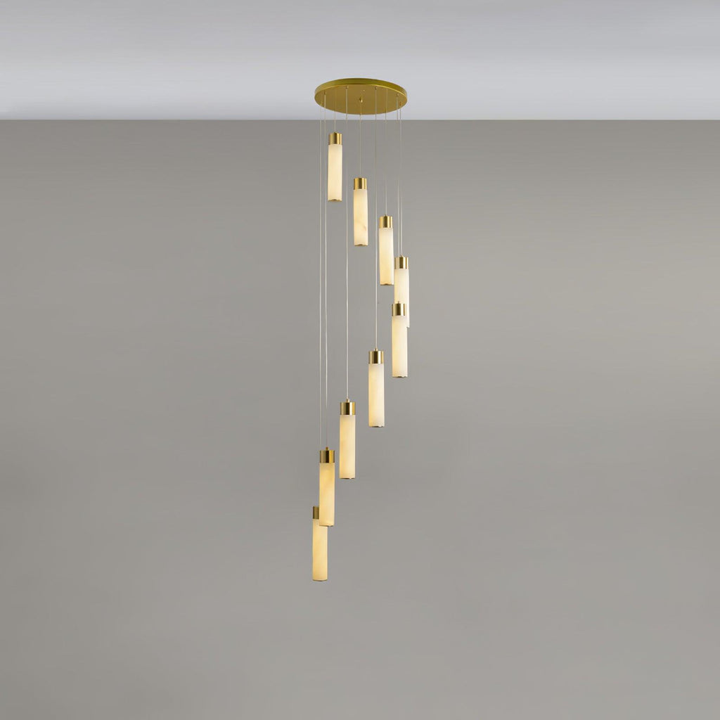 Nine rods dropping in a longer spiral, each lit tube capped with a polished brass collar.