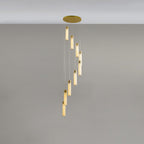 Nine rods dropping in a longer spiral, each lit tube capped with a polished brass collar.