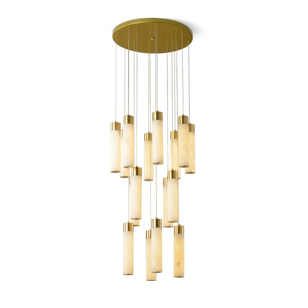 Aurelia chandelier on white with its tubes lit warm, brass caps and canopy clearly visible.