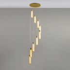Nine-light Aurelia chandelier hanging in a slow spiral from its brass canopy in a grey interior.