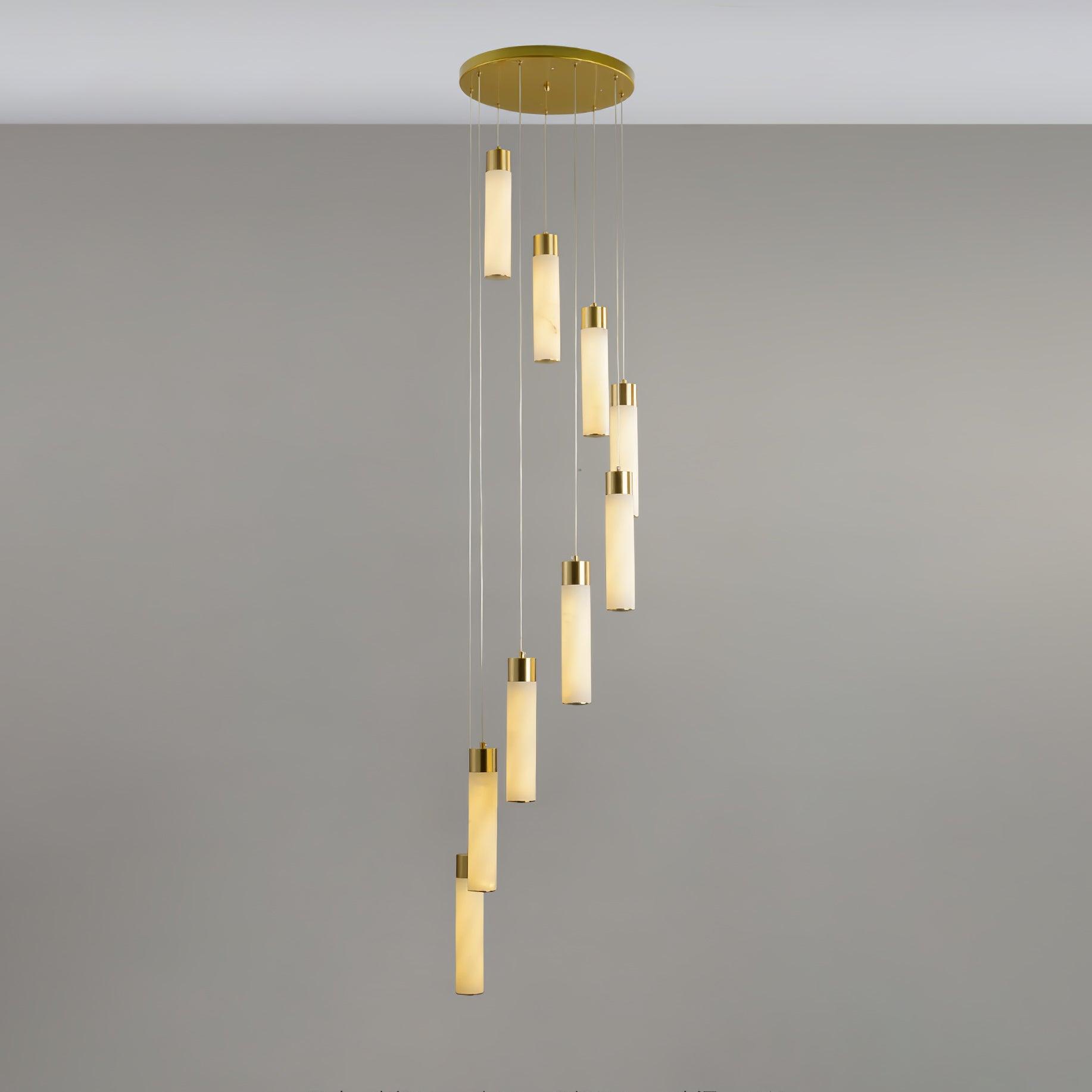 Nine-light Aurelia chandelier hanging in a slow spiral from its brass canopy in a grey interior.