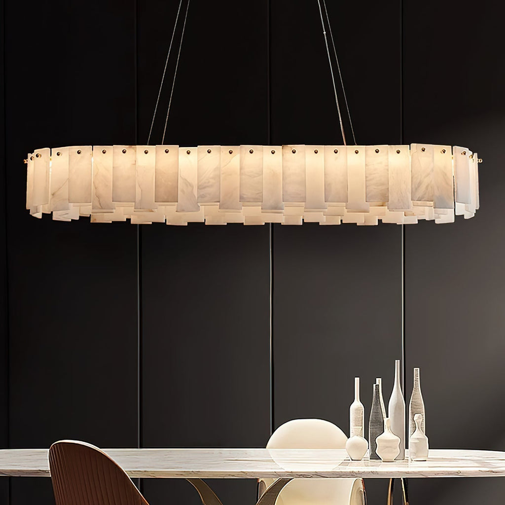 The long oval Aero chandelier lit above a marble dining table, glowing warm against a dark panelled wall