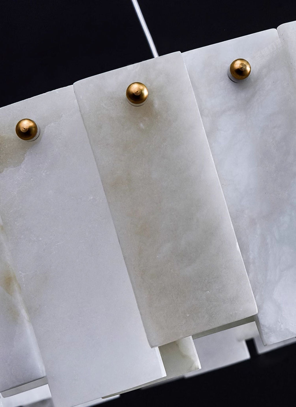Close-up of the Aero chandelier's alabaster panels, each pinned by a small brass ball stud