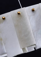 Close-up of the Aero chandelier's alabaster panels, each pinned by a small brass ball stud
