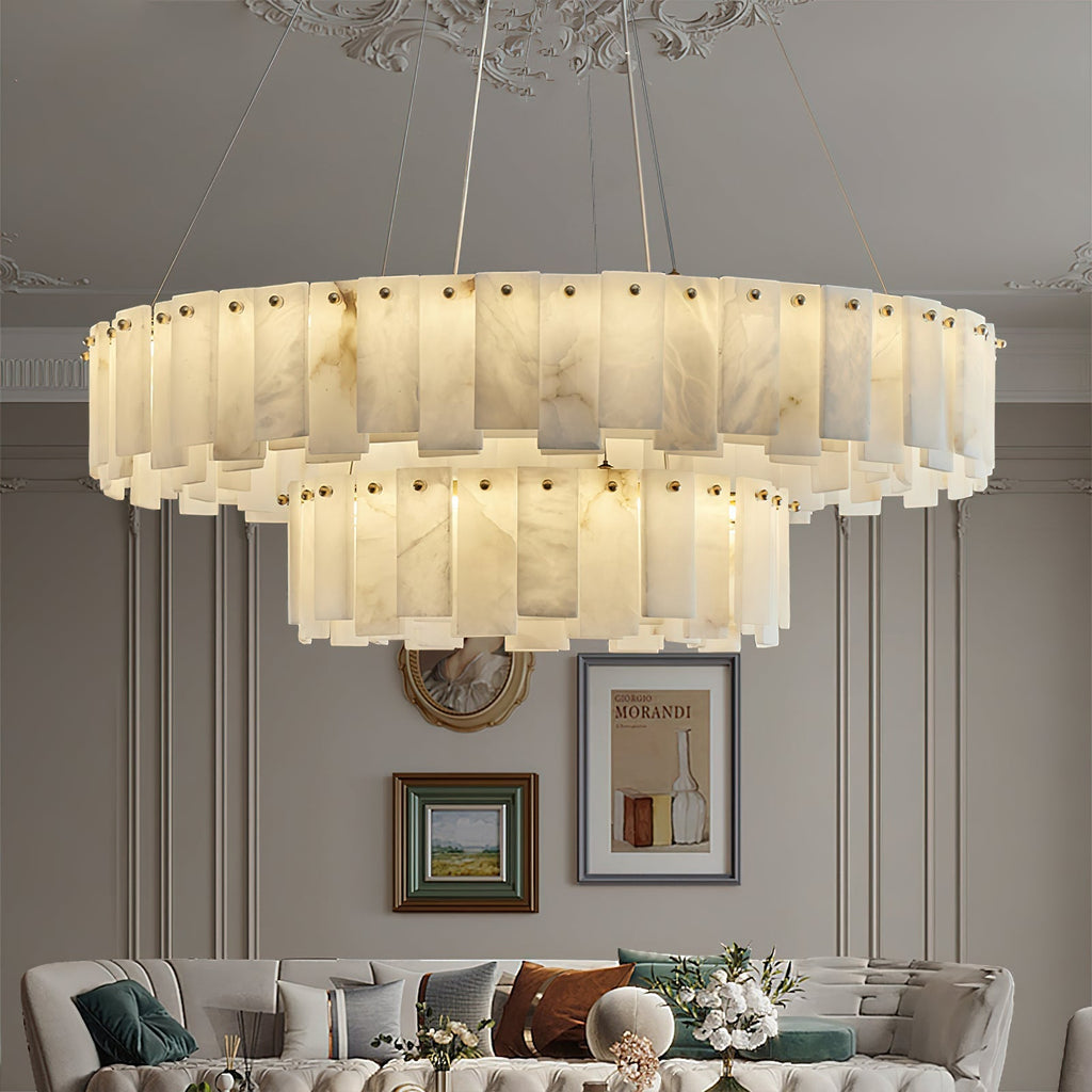 Aero round chandelier lit in a classic room beneath an ornate ceiling rose, above a tufted sofa