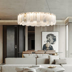 The chandelier lit in a stone-panelled living room, a framed portrait on the wall beyond.