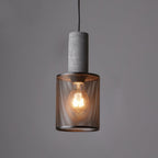 Cement and wire mesh pendant light glowing above a dining table
