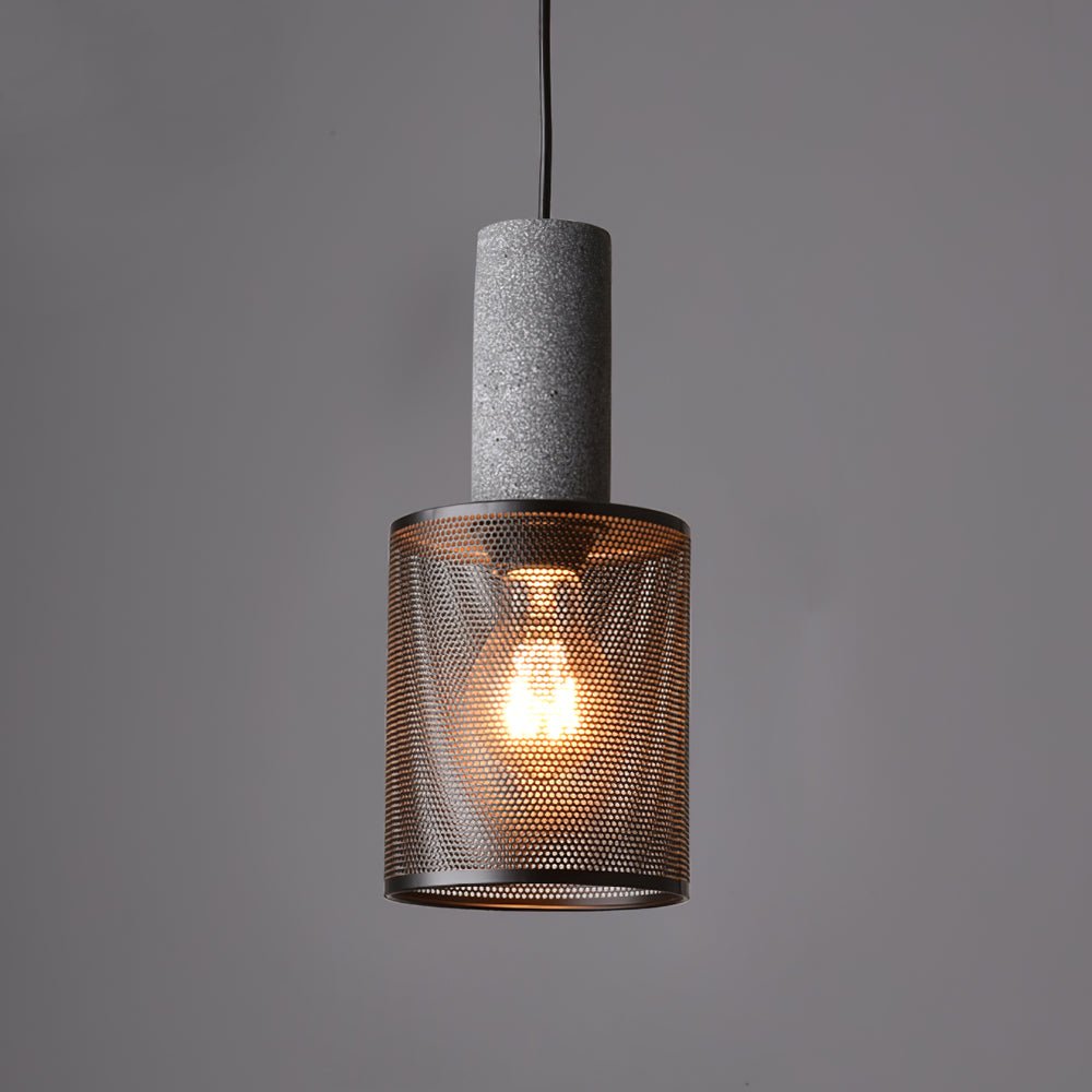 Cement and wire mesh pendant light glowing above a dining table