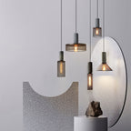 Black mesh pendant light glowing warmly above a counter