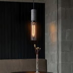 Cement mesh pendant light hanging beside a brick wall