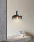 Cement mesh pendant light shadow play across a textured wall