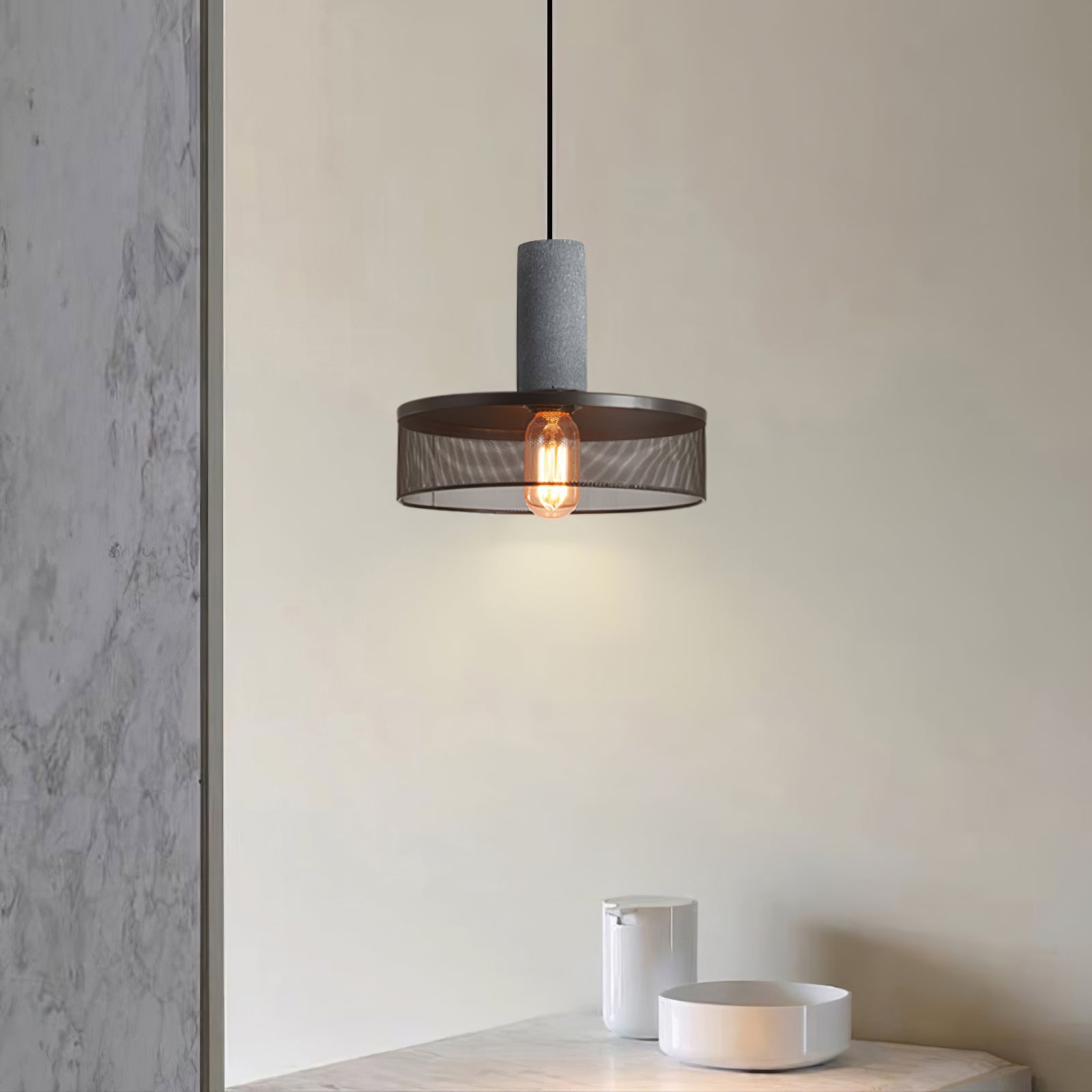 Black wire mesh pendant light with cement top in soft light