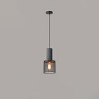 Cement mesh pendant light lit above an industrial dining setup