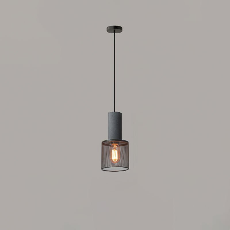 Cement mesh pendant light lit above an industrial dining setup