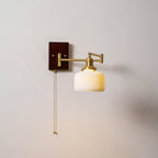 Sculptural white ceramic wall lamp on brass mount lit warmly