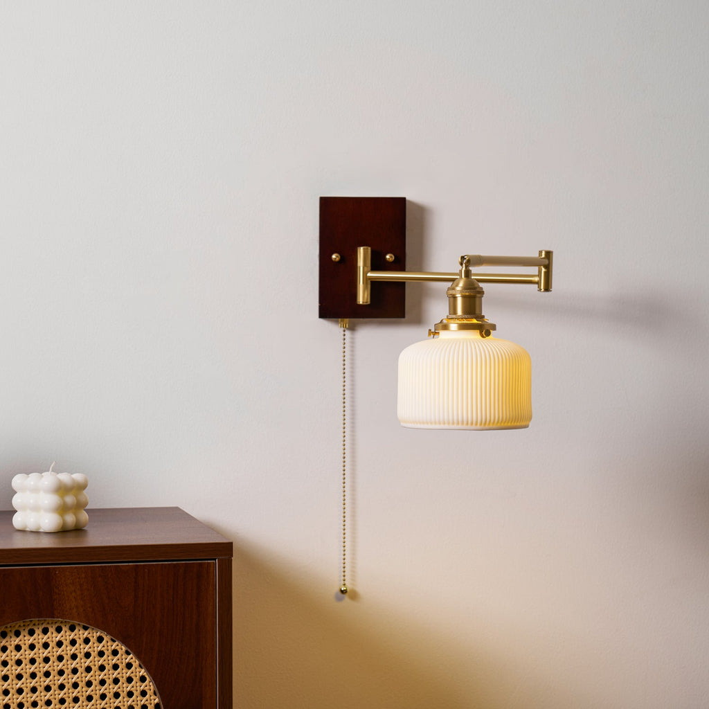 White ceramic wall lamp with brass hardware shown from the side