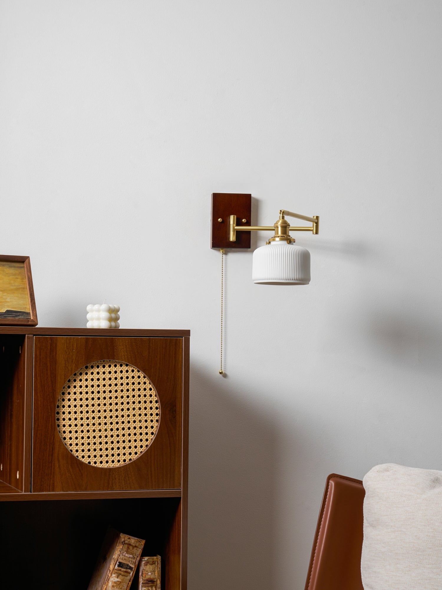 Sculptural ceramic wall lamp glowing softly with brass detail