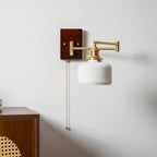 Sculptural white ceramic wall lamp on brass against a soft wall