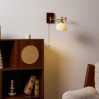 White ceramic wall lamp on brass mount glowing through the glaze
